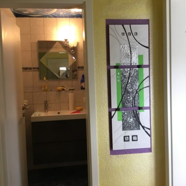 Badtür offen mit Blick auf Spiegel und Waschbecken