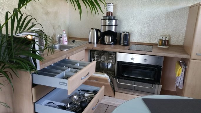 Einbauküche mit Geräten und geöffneten Schubladen